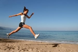 Happy girl running alone on the beach