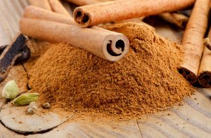 Cinnamon sticks and powder on wooden table. Selective focus