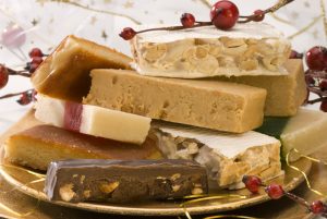 Typical spanish Christmas nougat in a golden plate. Selective focus.